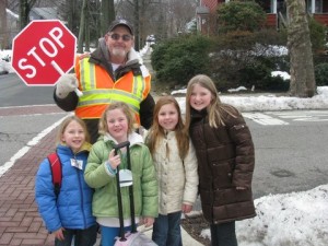 Jim Schroeder poses with Forest Avenue School 2nd graders (lt. to rt) Clara Frizzi, Caroline Gault, Monica Egnezzo and Annie Johnson at his post on the corners of Forest and Hillside Avenues.