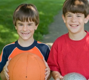 Three Boys Holding Sports Balls