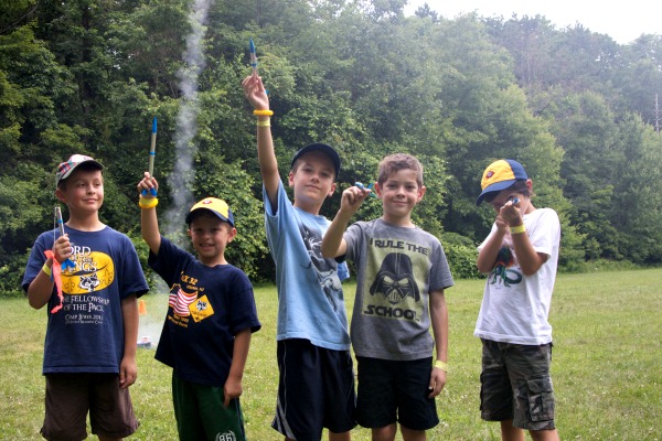 George Donnelly, Landon Lareau, Evan Carlson, Mark Serra and Elliott Ziebert (l-r) pose with their rockets while one blasts off behind them!