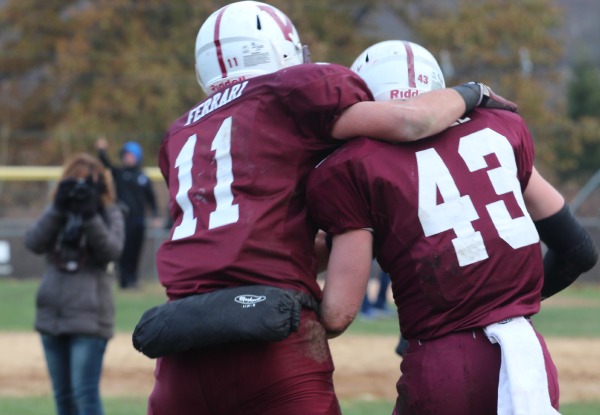 Bill Ferrari, back for his first game since breaking his arm in September, congratulates Luke Connell on his TD. 