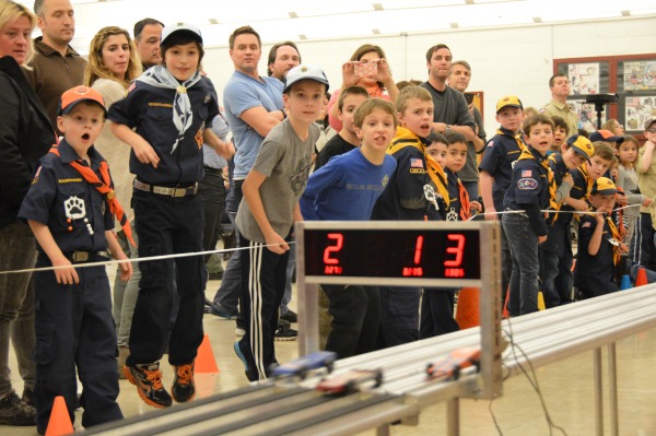 With a sense of unbridled anticipation, the scouts watch their cars cross the finish line.
