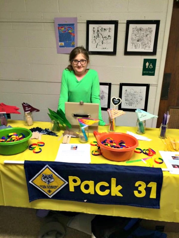 Pack 31 Scout Mikey Harris' sister Gabi selling wristbands and flags at the "Connor's House" fund-raising booth at Forest Avenue School's Family Fun Night.