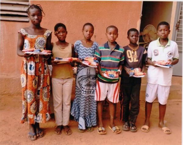 Students at the school in Burkina Faso show off materials bought with the funds by VHS students.