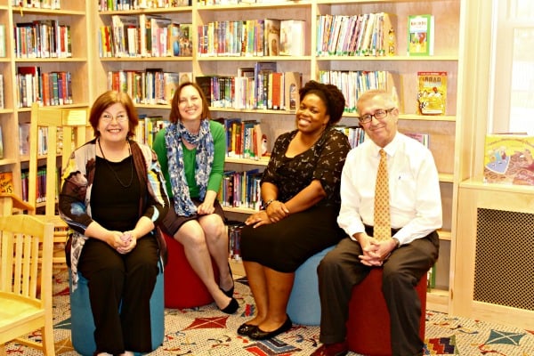 Librarians Cheryl Ashley, Catherine Adair Williams, Precious Mack and Bill Trafton, roosting on the new poofs in the Library's Children's Room.
