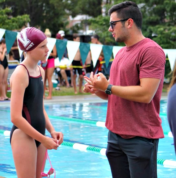 aves head coach Nick Hennig speaks with swimmer Katie Hunt after a race.